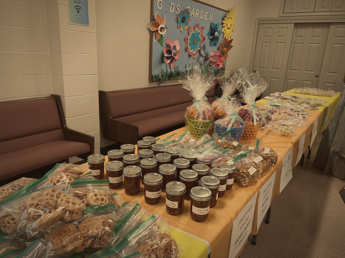 Harvest Festival tables lined with homemade mango pickle, snacks, and fruit baskets