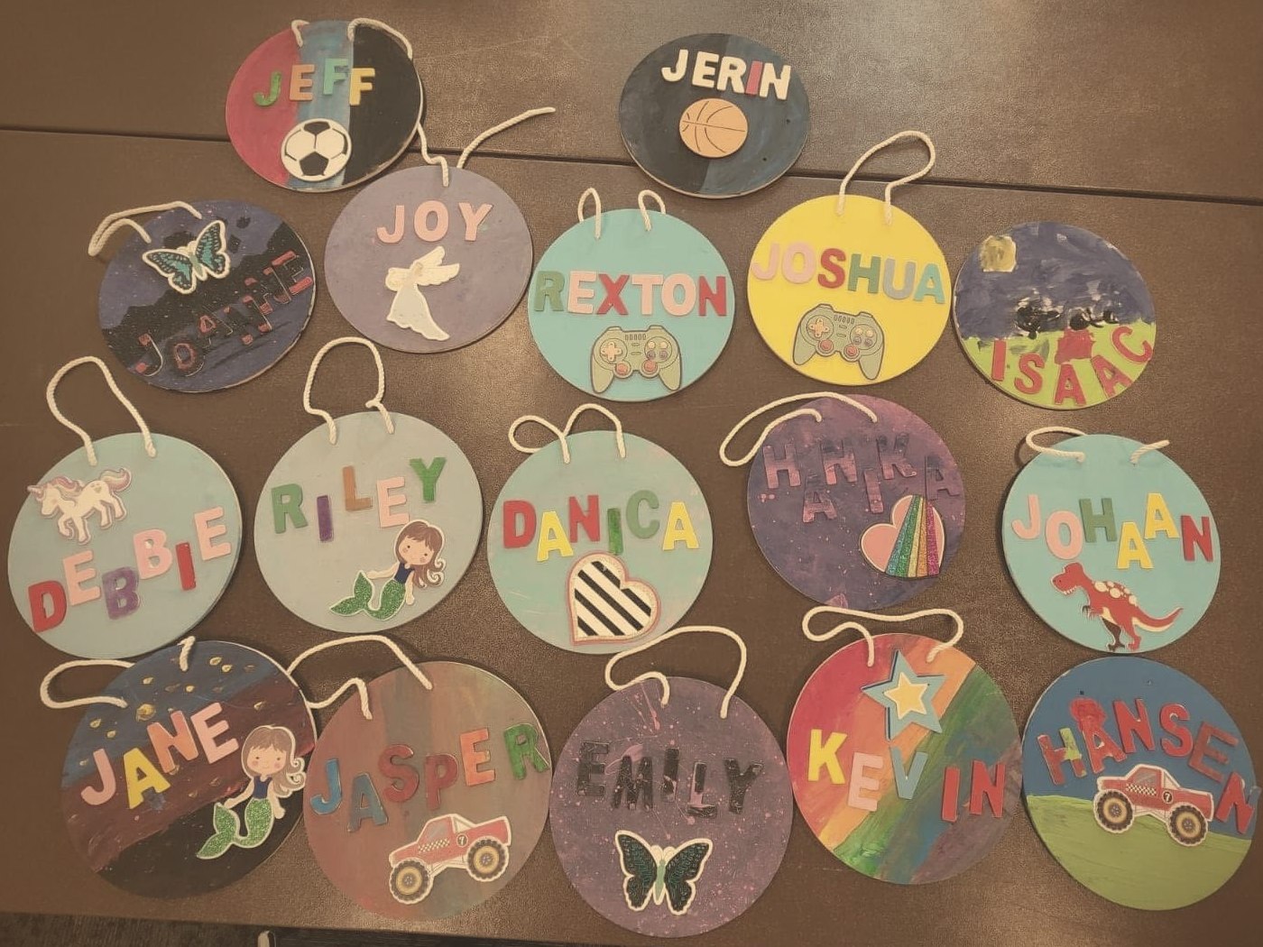 Round painted ornaments, each decorated by a child with their own name and favourite picture